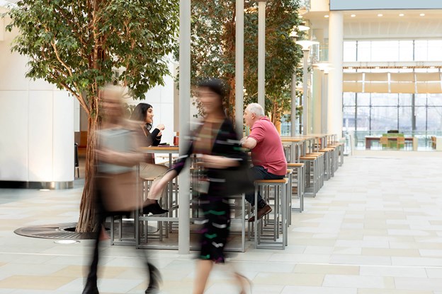 Two blurred figure in a large room.