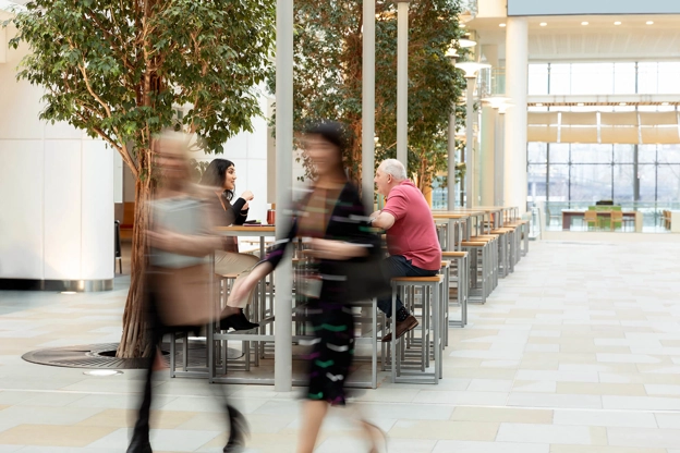 Two blurred figure in a large room.