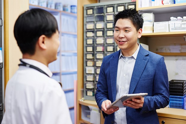Two men talking in lab over tablet